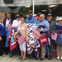 <p>Christie Ruiz of Christie&#x27;s Quilting Boutique, front, with flag, stands with veterans who received quilts on Saturday.</p>