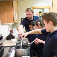 <p>Ridgefield Academy science teacher Jerry Nash assists students in the making yogurt. </p>