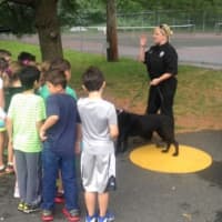 <p>A handler from the Ramapo Police Department tells children from Sloatsburg Elementary School about the role of police dogs in emergencies.</p>
