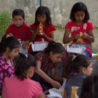 <p>Children eat lunch at earthquake-ravaged Nepal, where Ridgefield Academy chef Ipsa Lama visited over the summer to support relief efforts.</p>