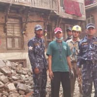 <p>Relief workers stand near rubble in Nepal after an earthquake in April.</p>