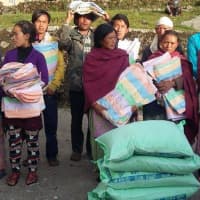 <p>People in Nepal grab blankets and tarps after an earthquake in April devastated their homes.</p>
