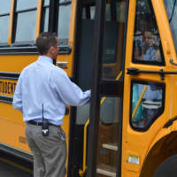 <p>Coaxing a young student off the bus Tuesday at Branchville Elementary School in Ridgefield. </p>