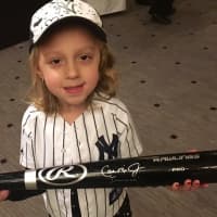 <p>Callie holds a Cal Ripken, Jr. autographed baseball bat.</p>