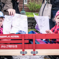 <p>Young girls ride in a wagon and encourage runners during Sunday&#x27;s race in Ridgefield.</p>