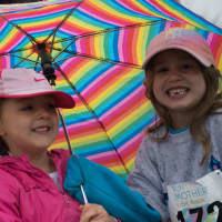 <p>Girls keep dry under an umbrella at Sunday&#x27;s Run Like A Mother 5k in Ridgefield.</p>