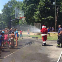 <p>Santa sprays water to the delight of campers in Friday&#x27;s visit.</p>