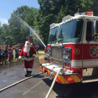 <p>Santa and Engine 8 bring relief to a sizzling afternoon Friday at Boys and Girls Club of Greenwich Camp Simmons.</p>