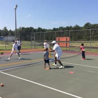 <p>Marvin Tyler works with a young tennis player on his form.</p>