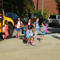 <p>A crowd gathers as kids leave the bus after their first ride of the new school year in Danbury. </p>