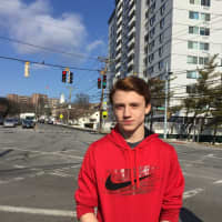 <p>Stamford High student Christian Hamilton, with Stamford High in the far background. He said an announcement over the loudspeaker system told everyone to evacuate the school on Tuesday.</p>