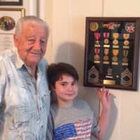 <p>World War II vet Armondo &quot;Chick&quot; Gallela, 95, of Sleepy Hollow, shows 10-year-old Ari Kotler his medals.</p>
