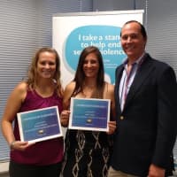 <p>Kerilyn Whitehead, left, and Jessica Feighan show their commendations to Cliff Benham, a board member with The Center.</p>