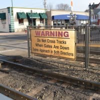 <p>A sign at the train station in downtown Ramsey warns pedestrians not to cross the tracks when the safety gates are down.</p>