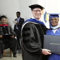 <p>Seminary president Hugh Spurgin hands a diploma to Sister Christiana Mmadu of Nigeria during commencement exercises at the Unification Theological Seminary in Barrytown on Saturday.</p>