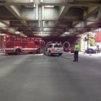 <p>Norwalk police and fire crews respond to a crash Wednesday under the railroad trestle.</p>