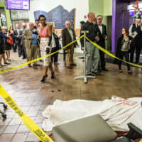 <p>A human form covered in a red-stained sheet and yellow police tape were among Murder Mystery Night props at the New Rochelle Public Library.</p>