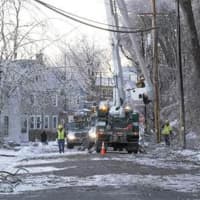 <p>Mutual aid crews work on McEntee Street in the City of Kingston to make repairs on Sunday.</p>
