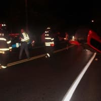 <p>Firefighters begin to clear debris from the roadway on Route 6N following an early morning rollover accident.</p>