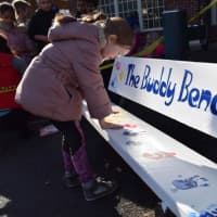 <p>Bronxville Elementary School students, who proposed the idea about the Buddy Bench to improve recess at their school, decorated the bench by leaving their handprints on it.</p>