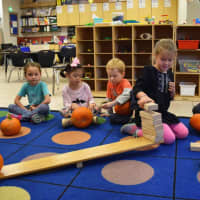 <p>Bronxville Elementary School students try to balance a pumpkin.</p>