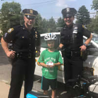 <p>Officer Lent and Sergeant Dispenza of the Larchmont Police Department with 8-year-old Gavin Lee of Larchmont.</p>