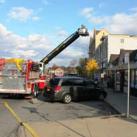 <p>Firefighters ride the ladder truck up to the second story of the building in order to attack the flames and smoke.</p>