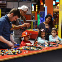 <p>Anthony Maddaloni, the new master model builder at LEGOLAND® Discovery Center Westchester in Yonkers, helps children choose interlocking plastic bricks to play with.</p>