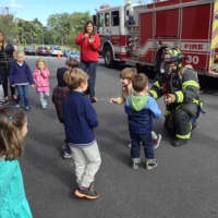 <p>A firefighter talks to children at Chapel School about fire safety.</p>