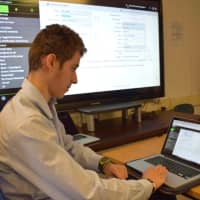 <p>Liam Siegal, a Bronxville High School senior and Student Help Desk member, answers a ticket before resolving a technology issue in the district.</p>