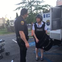 <p>Haina Just-Michael samples some New Rochelle police gear at National Night Out on Tuesday.</p>