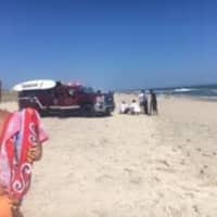 <p>Hank Joselson watches as EMS and police work on the man he saved from drowning at the beach.</p>