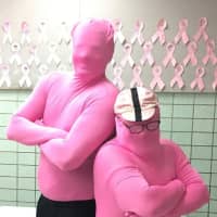 <p>Teachers Roman Litvak and Mike Mitchell dutifully wear their pink morph suits, after their election of sorts.</p>