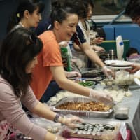 <p>Parents serve food at the Japanese Table-ACS Eats.</p>