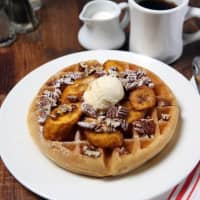 <p>Comfort food like this plate of waffles topped with bananas and walnuts is highlighted in the menu at Judys Bar + Kitchen in Stamford.</p>