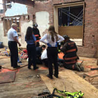 <p>Westport firefighters help two workers injured in the collapse of scaffolding at the Bedford Square construction site on Wednesday afternoon.  </p>