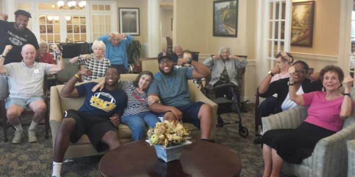 Pace University football players Jorge Geronimo, Adam Wooten and Prince Unaegbu are shown with some of the residents at Atria Briarcliff Manor. The athletes ran an exercise program this past school year at the facility.