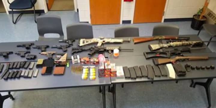 Seven handguns, six rifles, numerous high capacity magazines, ammunition, marijuana, and various firearm equipment were seized by police.