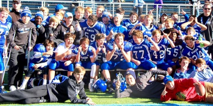 Darien 7th grade youth football players celebrate after the Wave and Blue were named co-champions of the Fairfield County Football League.