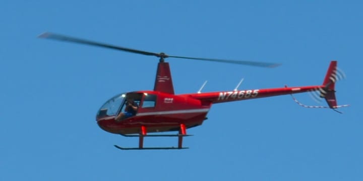 A zoomed version of a photo that shows a red helicopter flying over downtown Armonk.The helicopter&#x27;s tail number is visible.