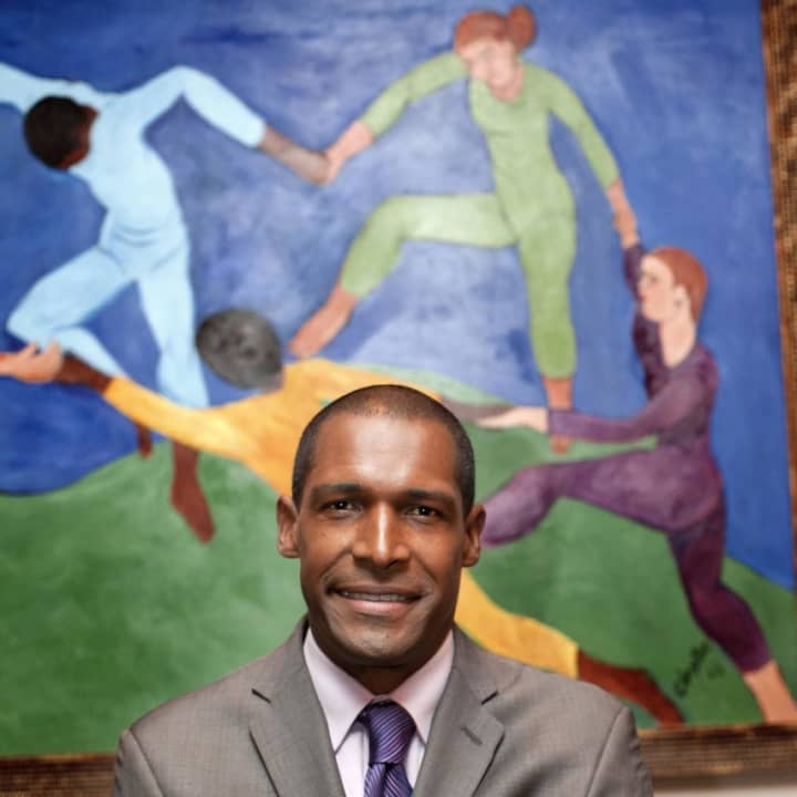 New Rochelle artist Alvin Clayton in front of his original painting &quot;Circle of Friends.&quot;