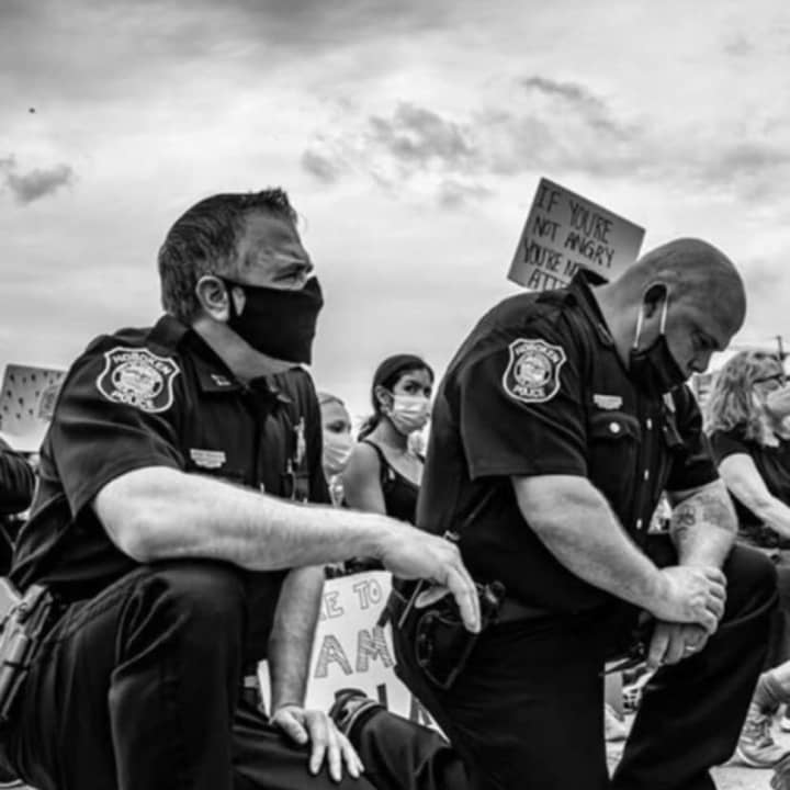 Police officers kneel in solidarity during a Hoboken protest in early July.