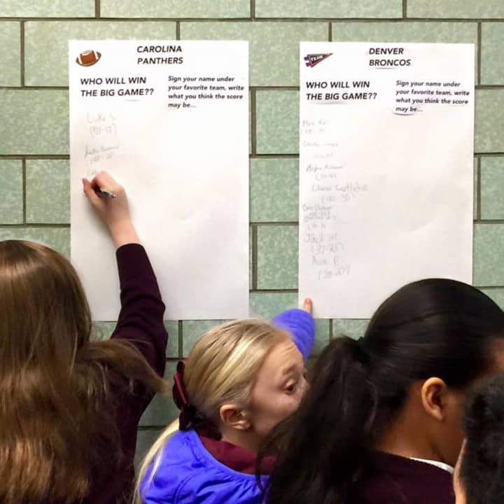 Students at St. Anthony School in Hawthorne sign a paper for which team they think will win Super Bowl 50.