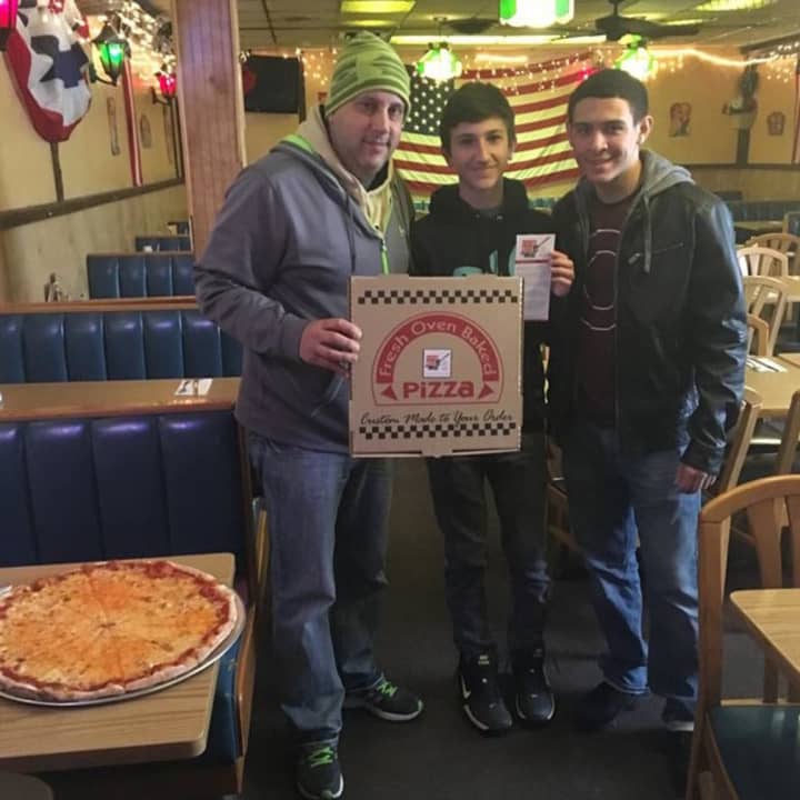 Garfield EPIC members help put stickers on pizza boxes at Barcelona&#x27;s.