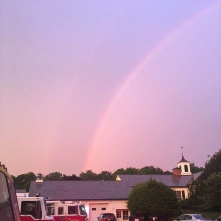 A rainbow rises over the Weston Volunteer Fire Department after Monday&#x27;s storm.