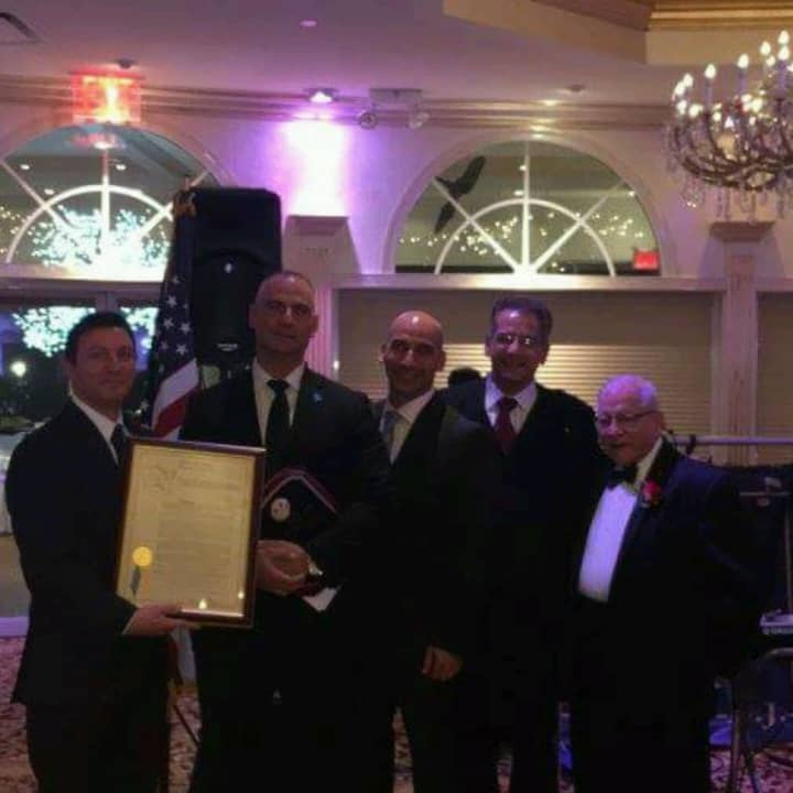 Former New Rochelle Police officer Christopher Greco (pictured second from left) is accused of stealing $24,000 from a charity organization that he co-founded, officials said.