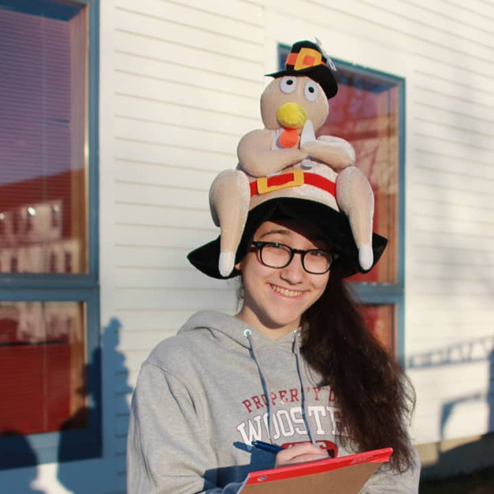 A student from the Wooster School in Danbury gets into the season as she and her classmates deliver the 129 turkeys donated for Thanksgiving meals. 
