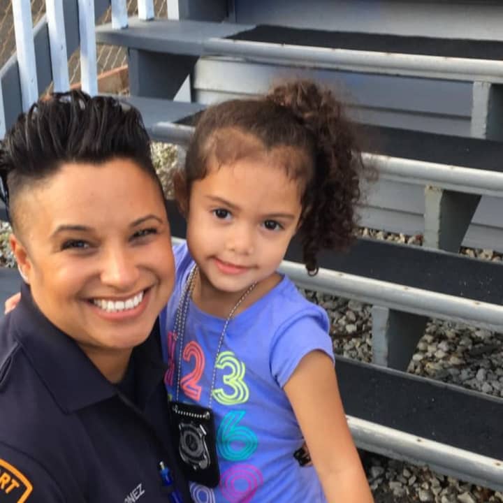 Officer Sandy Gonzalez-Quinonez poses with little Saydie Ramos.