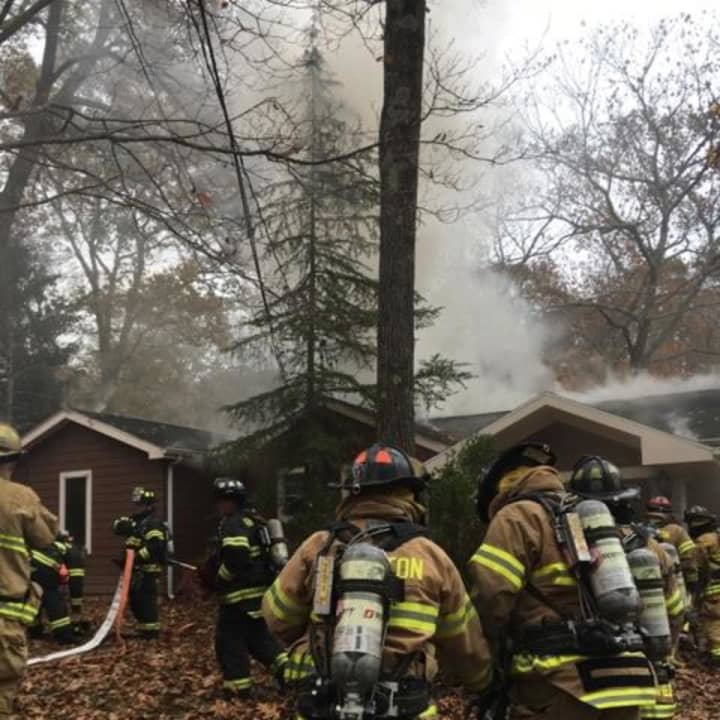 Weston and Fairfield firefighters respond to a blaze at a house on Saw Mill Road in Weston on Saturday.