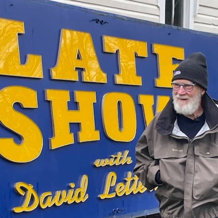Funnyman David Letterman standing in front of the sign in Darien.